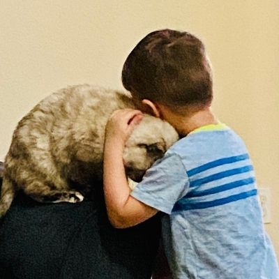 little boy hugging dog