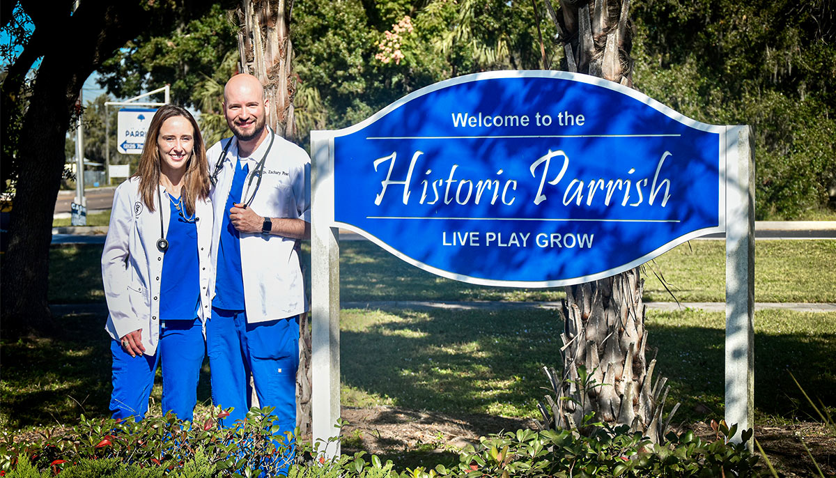 Drs. Zachary and Morgan Pearl standing next to Historic Parrish sign